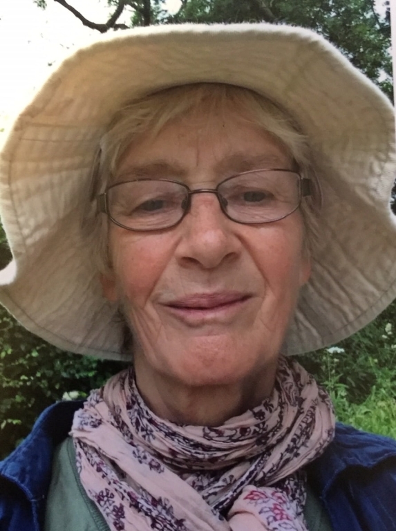 Woman in a sun hat and scarf smiling 