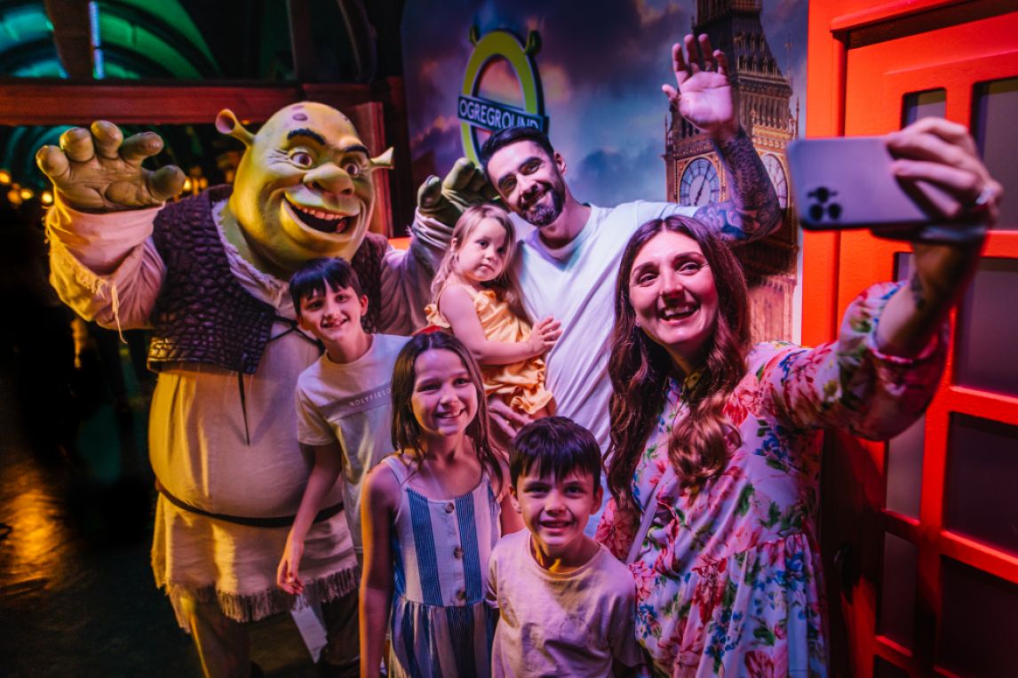 A family taking a photo with a Shrek mascot