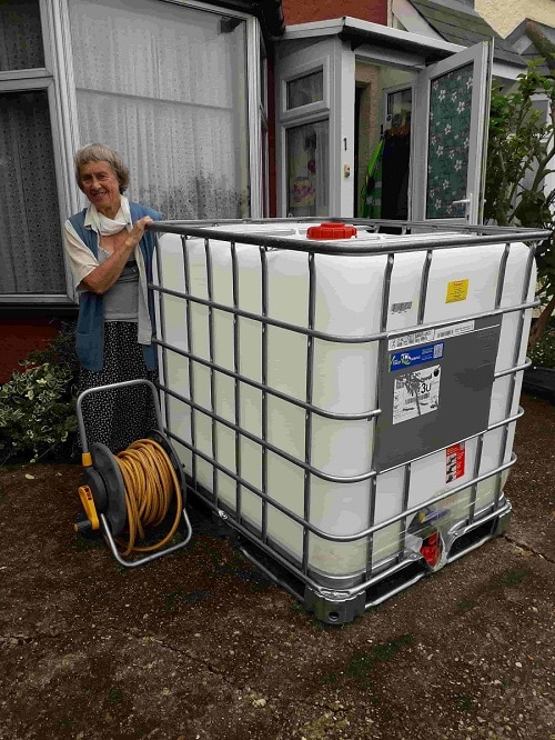 Julia Prigg standing next to a big white water tank