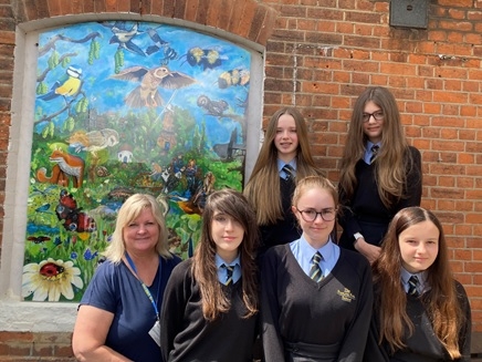 Sweyne Park School pupils and artist Mel Stapleton next to Rayleigh Station mural