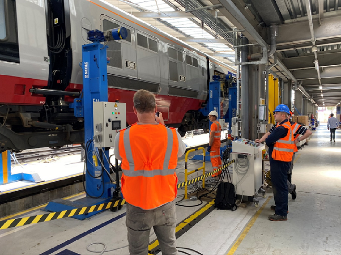 A train being raised in the air for engineers using lifting equipment