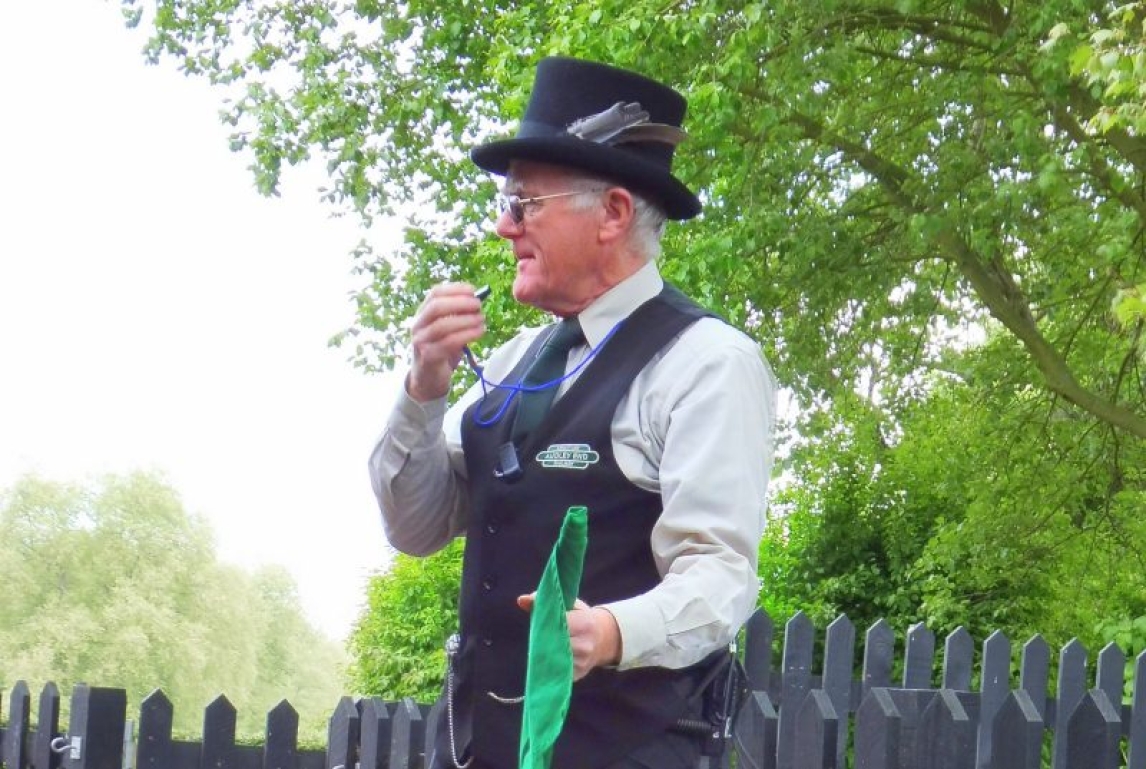 A man in a top hat with a whistle